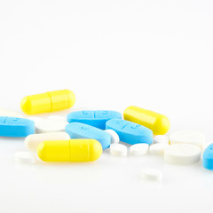 Assorted pharmaceutical medicine pills, tablets and capsules on white background