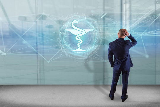 Businessman in front of a wall with pharmacy medical icon on a futuristic interface