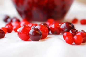Berries jam in a bowl and berries close-up on a white tablecloth