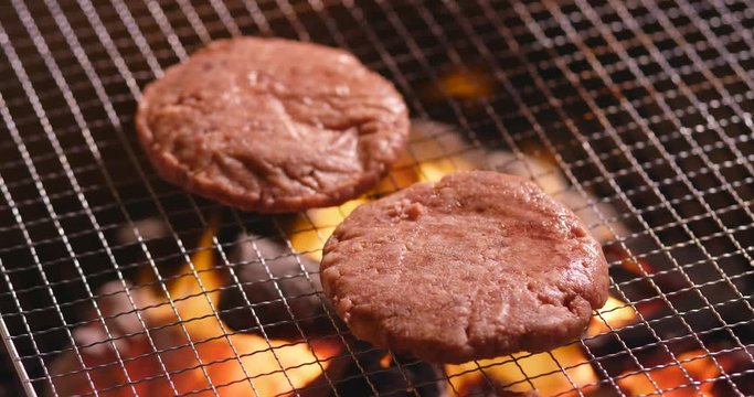 Grilling burger on BBQ fire
