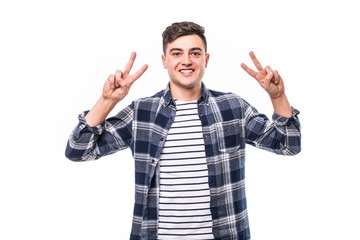 young man posing in white isolated studio background with hand in pocket while showing the victory sign and looking at the camera