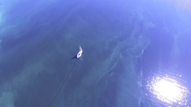 4K Aerial.  Fly around white small yacht in  gulf or sea.Top view 