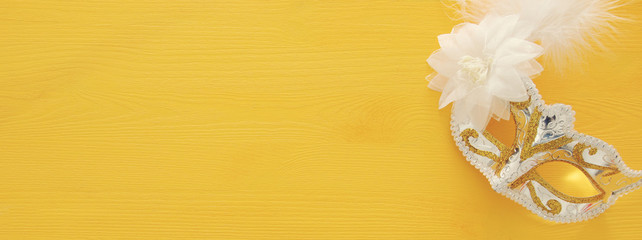 Image of elegant venetian mask over colorful background.