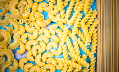 Mix of pasta on wooden background. Diet and food concept.