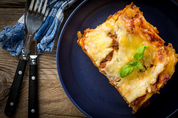 Piece of tasty hot lasagna with red wine.