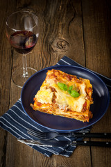 Piece of tasty hot lasagna with red wine.