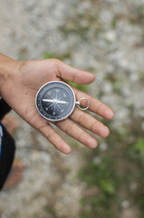 Compass in the hand against mountain. Adventure end travel background.