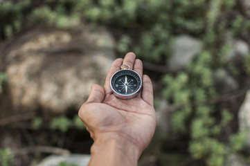 Compass in the hand against mountain. Adventure end travel background.