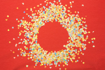 colorful paper confetti on red background