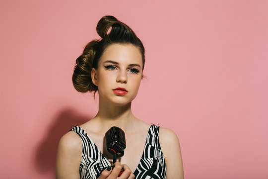 Pin up young girl on pink background, radio.