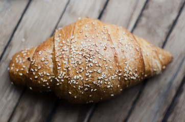 Fresh croissant on a wooden retro background. Top view