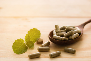  herbal drug or pill on wood background .