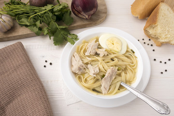 Appetizing chicken soup with noodles, with the addition of potatoes, carrot greens and bay leaf.