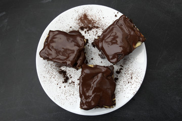 Appetizing chocolate cakes are located on a white plate close-up.