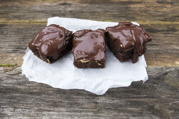 Appetizing chocolate cakes are located on an old wooden background.