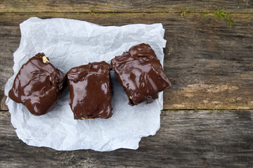Appetizing chocolate cakes are located on an old wooden background and copy space.