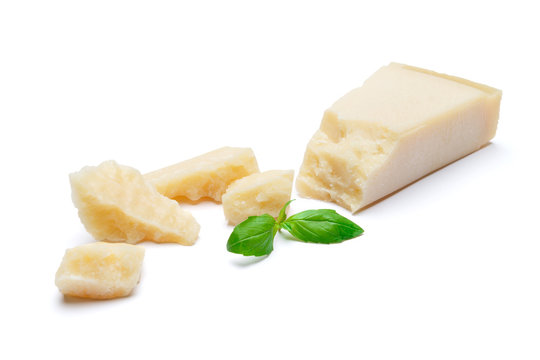 pieces of Parmesan cheese with basil on white background