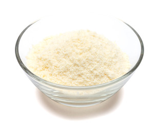 grated Parmesan cheese in glass bowl on white background