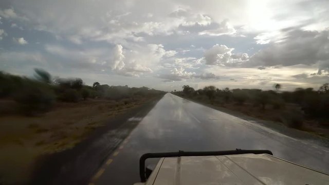 Jeep driving along wet african street