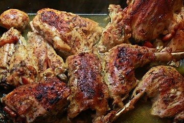 Pieces of roasted turkey meat in juicy sauce on a roasting pan 