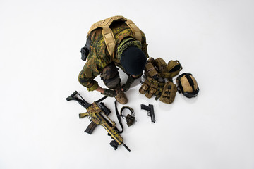 Top view defender tying shoelaces on footwear while preparing army uniform. Arrangement concept