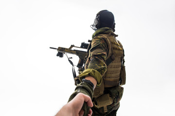 Defender keeping man by hand while turning back to camera. Military and help concept. Isolated