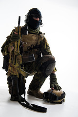 Portrait of calm peacemaker kneeling while holding assault rifle. Protection concept