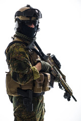Fototapeta premium Portrait of serene soldier holding assault rifle while looking at camera. Army concept. Isolated