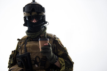 Portrait of calm defender in army uniform tasting cup of appetizing beverage. Rest and war concept....