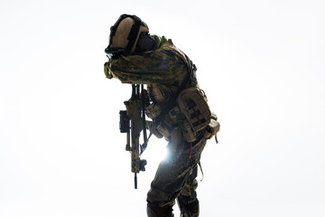 Fototapeta na wymiar Defender shutting appearance by arm while keeping assault rifle. Camouflage concept. Isolated