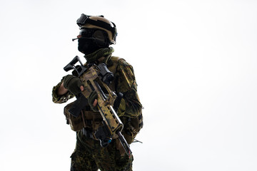 Fototapeta na wymiar Side view serene defender keeping assault rifle in arms while looking around with concentration. Protection and war concept. Isolated and copy space