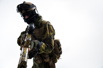 Portrait of severe soldier holding modern weapon in hands. He looking at camera. Attack concept. Isolated and copy space