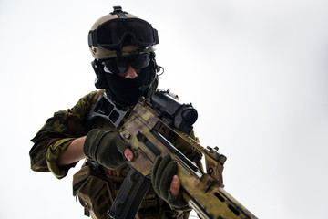 Fototapeta na wymiar Portrait of serious defender in helmet and balaclava keeping assault rifle. War concept. Isolated