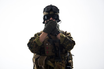 Portrait of serious soldier closing mouth by hands while wearing military uniform. Confidence concept. Isolated