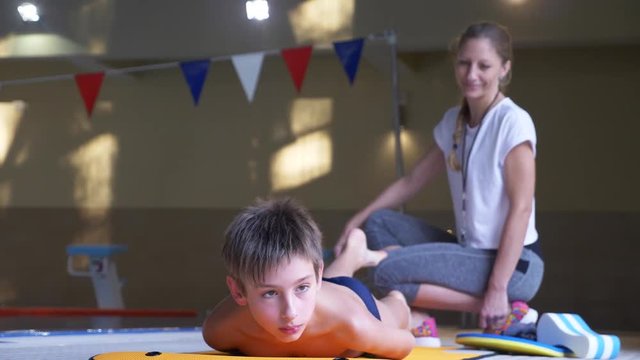 swim athlete training. The coach teaches the boy to dive into the sports pool. 4k, slow motion