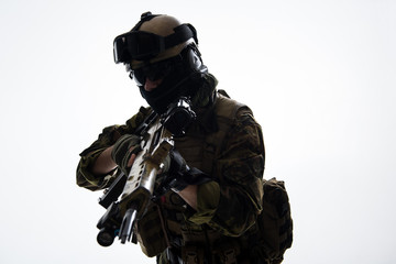 Portrait of serious defender wearing uniform while holding assault rifle. Military concept. Isolated