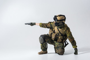 Side view severe soldier firing with pistol while wearing balaclava and helmet. War concept. Copy...