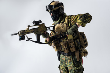 Side view severer peacemaker shooting assault rifle while taking machine gun clip from pocket....