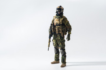 Full length portrait of orderly defender keeping assault rifle in arms. War and peace concept - obrazy, fototapety, plakaty