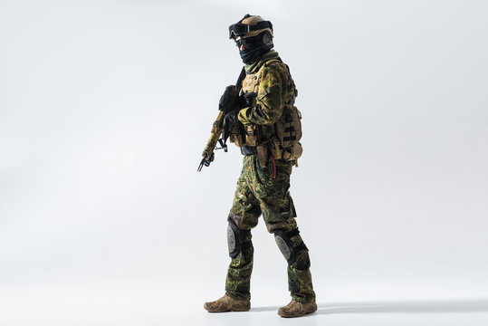 Full length portrait of serious peacemaker holding modern weapon in hands. Occupation concept