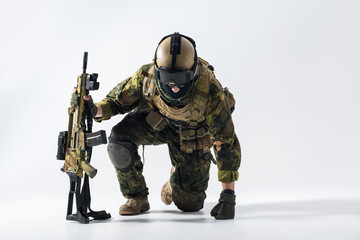 Portrait of stern defender rising from knees while leaning on weapon. Profession concept