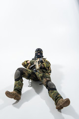 Full length portrait of grave defender lying on floor while shooting with assault rifle. Protection concept. Copy space