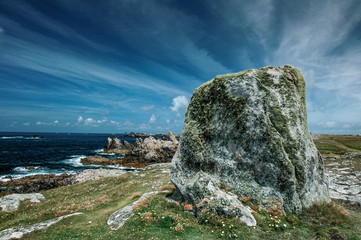 granite rocks stand out against a blue sky on the island Ouessant in Brittany, France