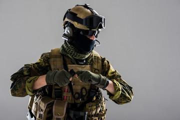 Portrait of grave man keeping bombshell in arms while telling by special microphone. Military concept. Isolated