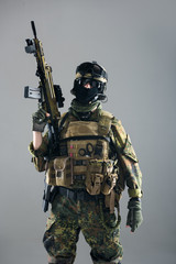 Portrait of serious man keeping assault rifle in hand. Occupation and army concept. Isolated