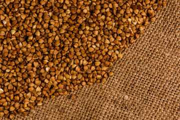 Pile of the raw buckwheat on sackcloth. Top view