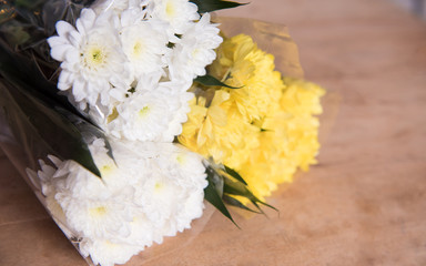 White and yellow flower on the wooden table
