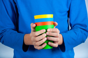 Close up of kid holding plastic cups in hands
