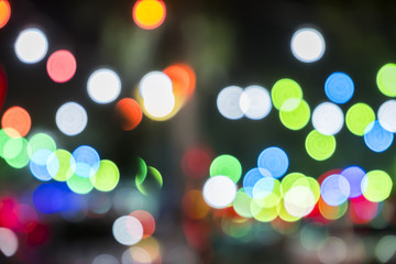 Bokeh background. Green, red and blue defocused bright bokeh circles and dark night background.