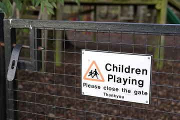 Children playing please close gate sign at play park in school